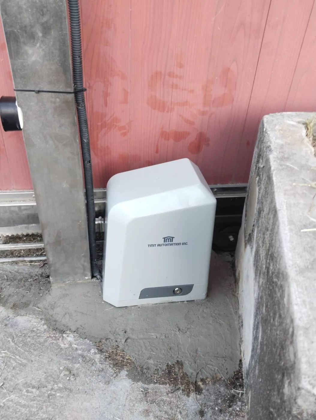 White BX series motor installed at the base of a sliding gate, rack fitted